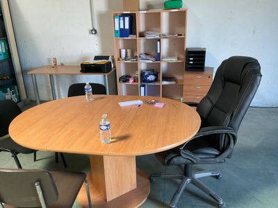 des tables et des chaises dans une pièce équipée d'une étagère et d'une bibliothèque