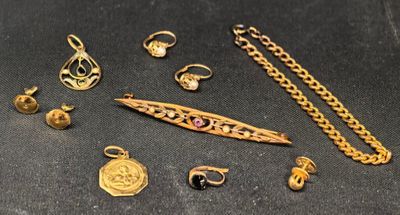 quelques bijoux en or sont posés sur une surface noire