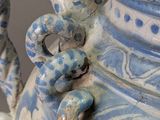 a blue and white vase with a handle on it