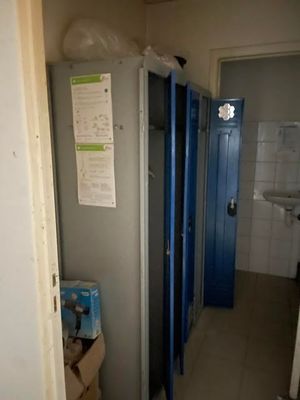 doorway view of a bathroom with blue lockers and a white sink