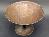 a close up of a metal bowl on a black surface