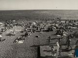 black and white photo of a crowded beach with people on it