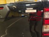 a reflection of a man standing in the back of a truck