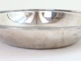 a silver bowl on a white table with a white background