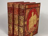 un livre rouge orné de motifs dorés sur un fond blanc