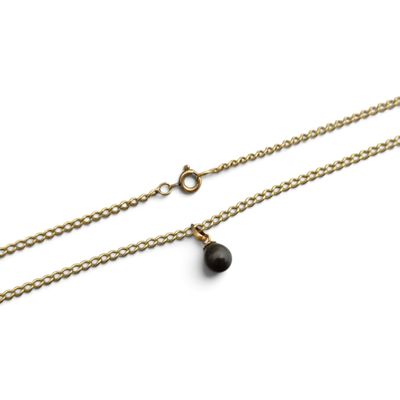 une chaîne en or ornée d'un pendentif en forme de larme noire