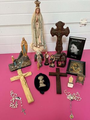 de nombreux objets religieux posés sur une table recouverte d'une nappe rose