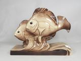 a figurine of a fish and a fish on a wave