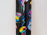 the skateboard is black and has colorful designs on it