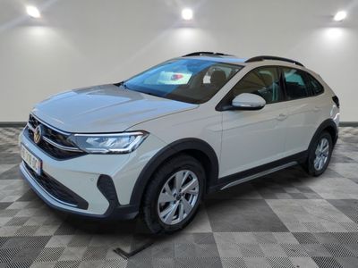 un SUV Volkswagen blanc garé sur un sol à damier dans un garage