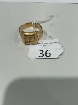 une bague en or posée sur une table blanche, avec une étiquette de prix dessus