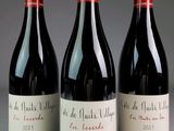 three bottles of red wine sitting on top of a table