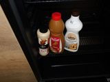 two bottles of liquid and a bottle of peanut butter in the refrigerator