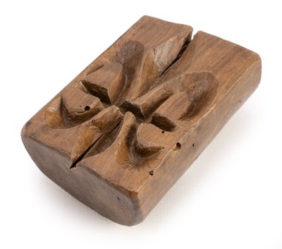 an old wooden block with a carved design on top of it