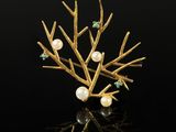 a close up of a gold tree brooch with pearls and emeralds