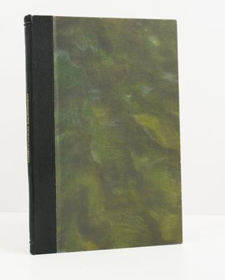 un livre à la couverture verte posé sur une table blanche