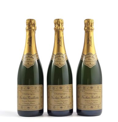 trois bouteilles de champagne posées les unes à côté des autres sur une surface blanche