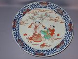 a plate with a painting on it sitting on a table