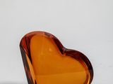 a glass heart shaped object on a white surface