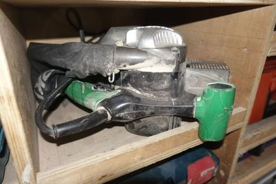 a picture of a cluttered cabinet with tools and a blow dryer
