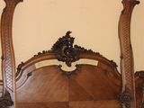 a bed with a wooden headboard and a mirror on the wall