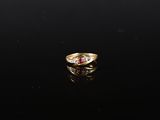 une bague en or sertie d'un rubis et de diamants sur un fond noir