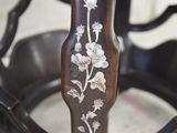 a close up of a wooden chair with flowers painted on it