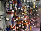 many different types of pens and pencils on the shelves