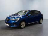 Une voiture bleue est garée dans une pièce aux murs blancs.