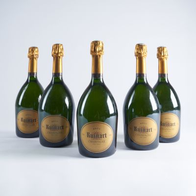 quatre bouteilles de champagne sont alignées sur une surface blanche