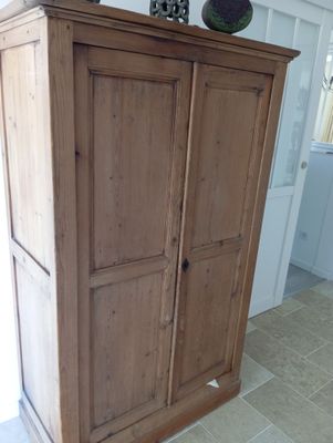 a tall wooden cabinet with a clock on top of it