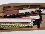 a cardboard box filled with different types of pens and pencils