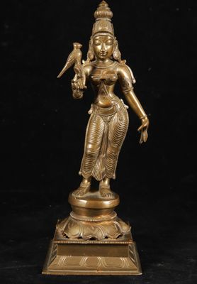 a bronze statue of a woman holding a bird on her arm