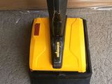 yellow and black vacuum cleaner sitting on the floor next to a door