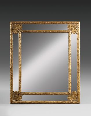 un miroir orné d'un cadre doré sur fond gris