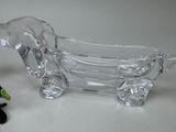 a glass dog figurine next to a glass bathtub