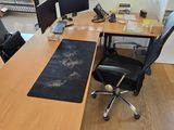 un bureau avec deux ordinateurs et une chaise devant une fenêtre