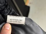 a close up of a person ' s hand holding a label on a jacket