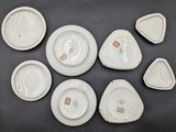six pieces of white pottery sitting on top of a black table