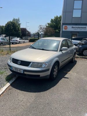 une voiture argentée garée dans un parking à côté d'un bâtiment