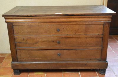 une petite commode en bois sur un sol carrelé