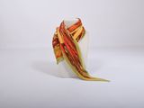 un vase blanc surmonté d'un foulard coloré