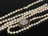 a pearl and diamond necklace with a clasp