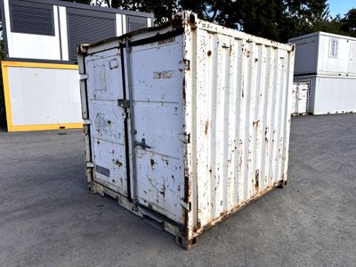a white container sitting in the middle of a parking lot