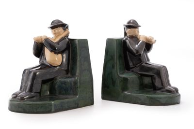 two figurines of a man sitting on a bench