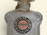 an image of a glass bottle of perfume on a white surface