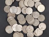 tas de pièces d'argent posées sur une surface noire, sur fond noir