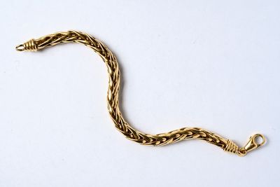 bracelet plaqué or avec un motif torsadé sur fond blanc