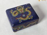 une boîte bleue ornée d'un dragon, posée sur une table