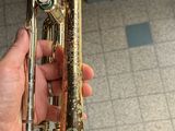 a person holding a trumpet in their hand on the floor